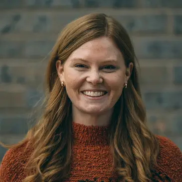 A woman in a red sweater smiling for the camera.