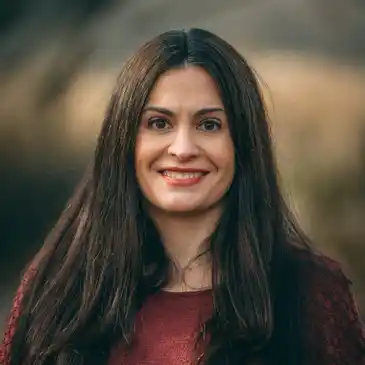 A woman with long hair is smiling for the camera.