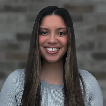 A woman with long hair smiles for the camera.