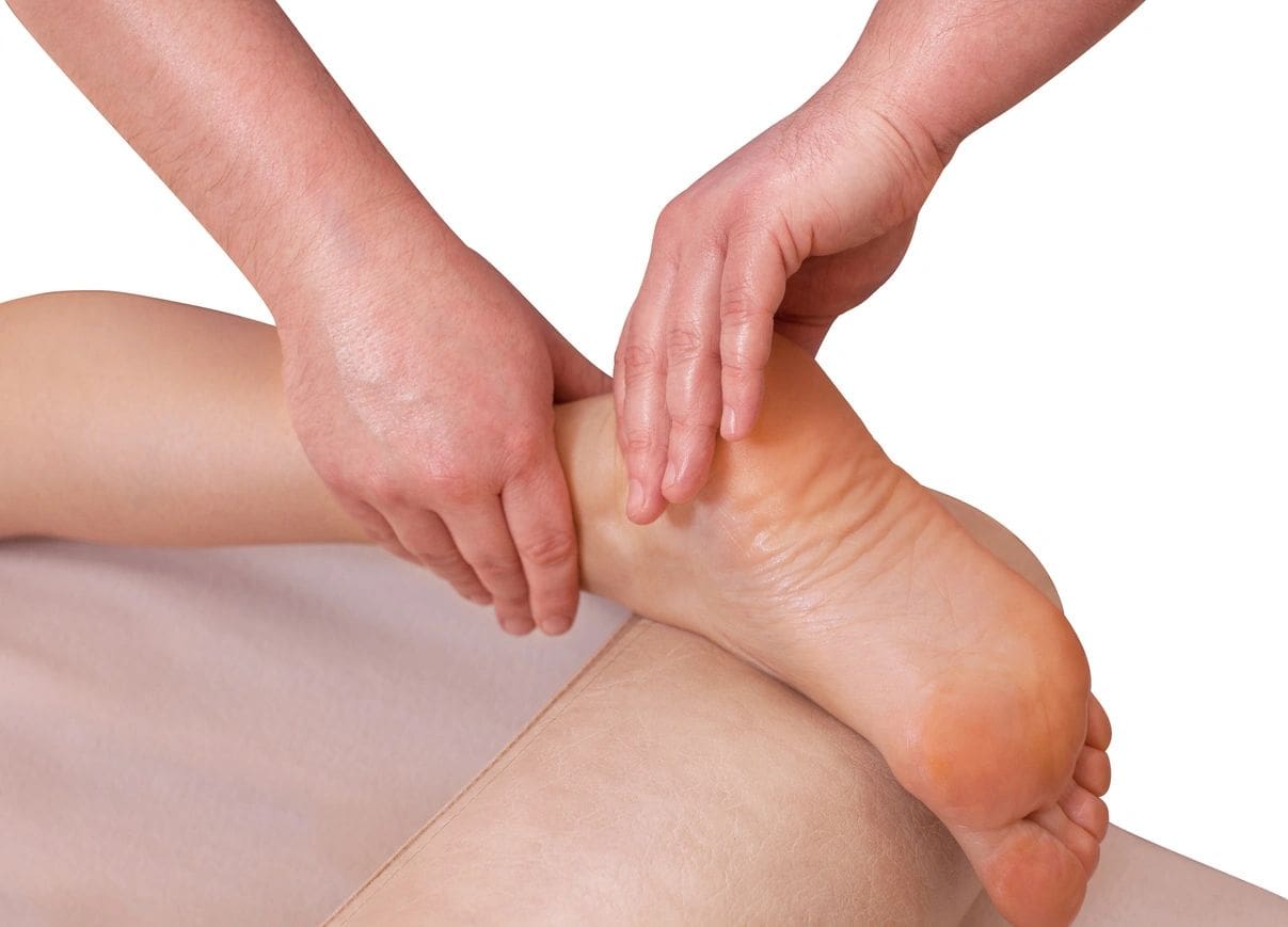 The doctor-podiatrist does an examination and massage of the patient's foot in the clinic.