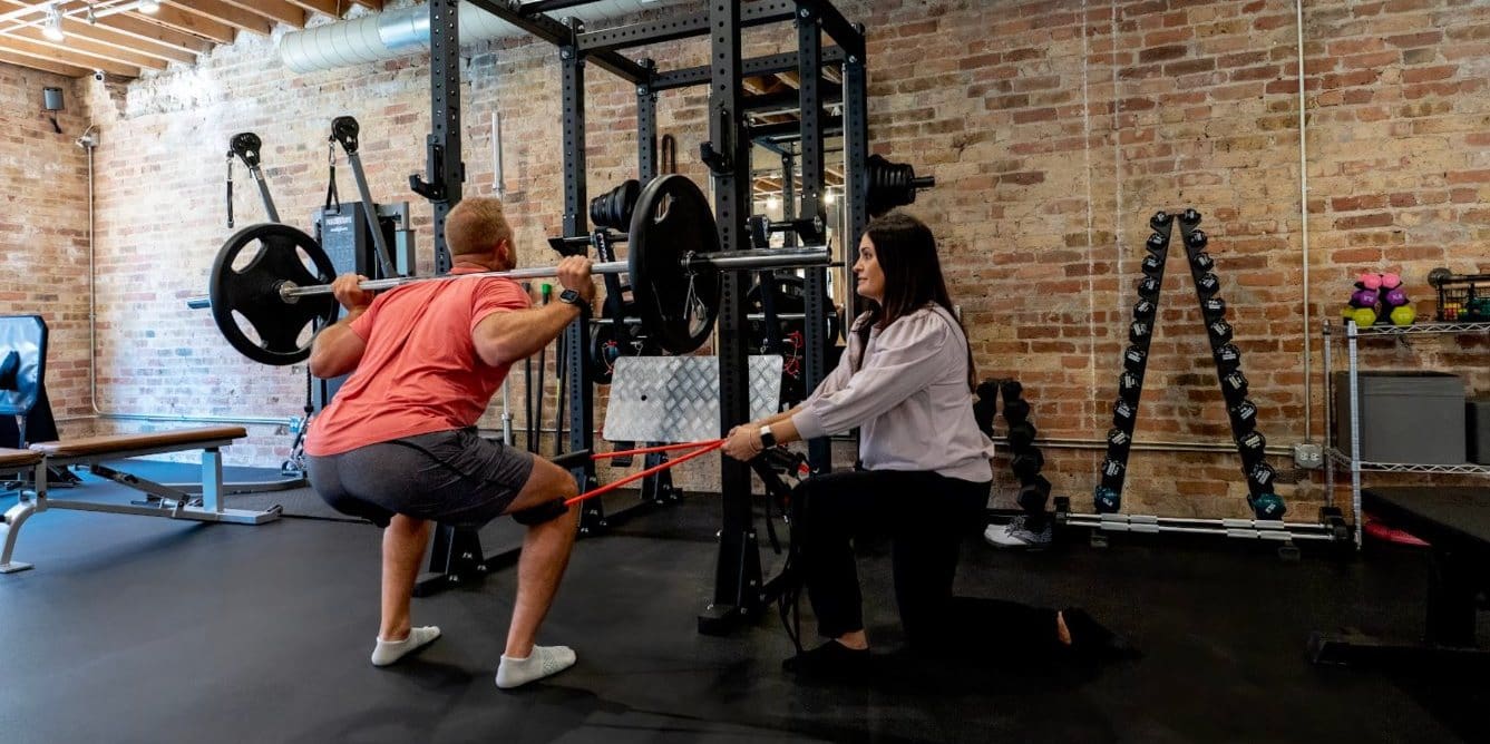 ACL rehab squat with band at Dynamic Physical Therapy Chicago